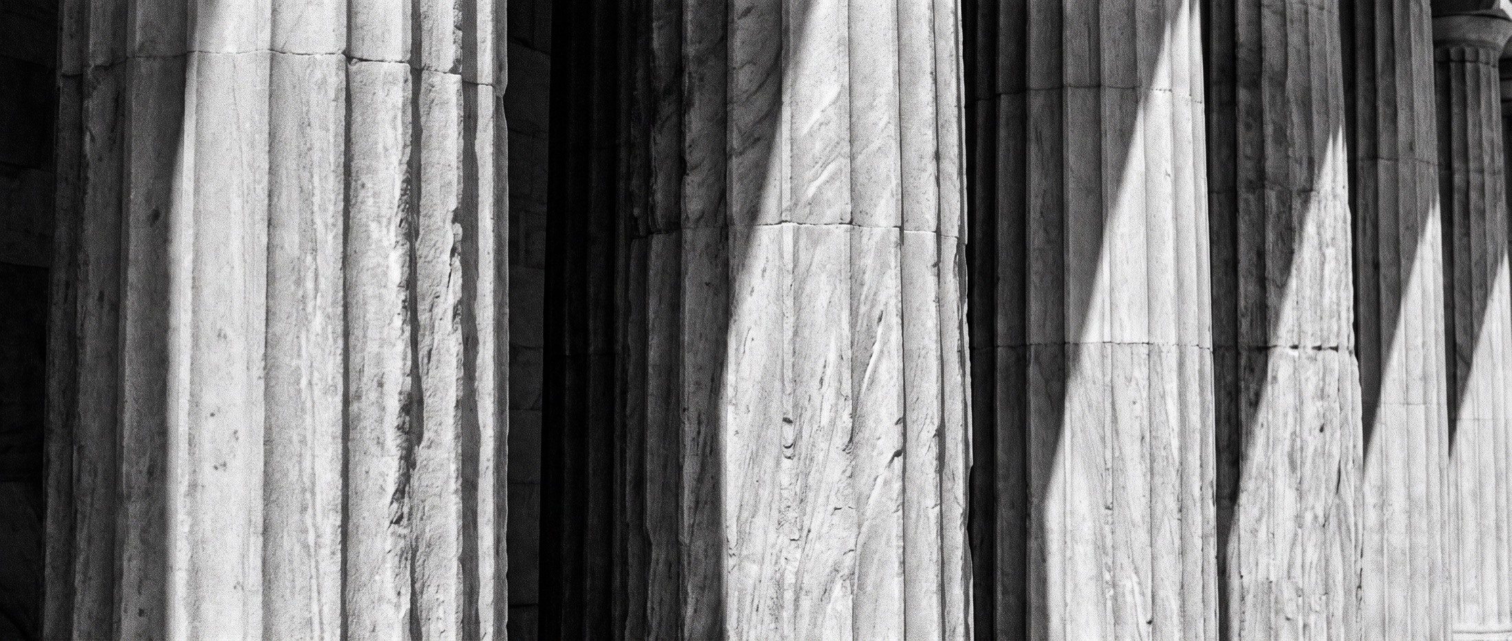 Raking light across the shafts of a stone colonnade